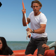 In this scene from shark thriller Great White, two women crouch in a life raft; between them is a man holding a makeshift spear.